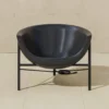 0003_GJ_KosmosChair2_Profile_.RGB_color.0000_1440x Black bowl-shaped salon sink on a metal stand, with an electrical cord on a beige tiled floor.