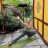 A woman in a yoga pose outdoors with a Heliosa 66 Black Heater behind her