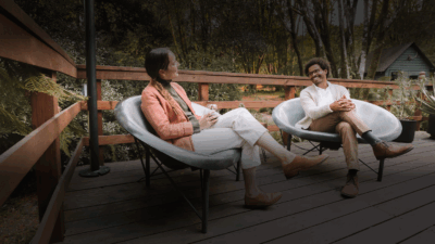 An happy couple seated in Helios chairs of Galanter & Jones heated furniture that is sold by Heating Green based in Bellingham, Washington
